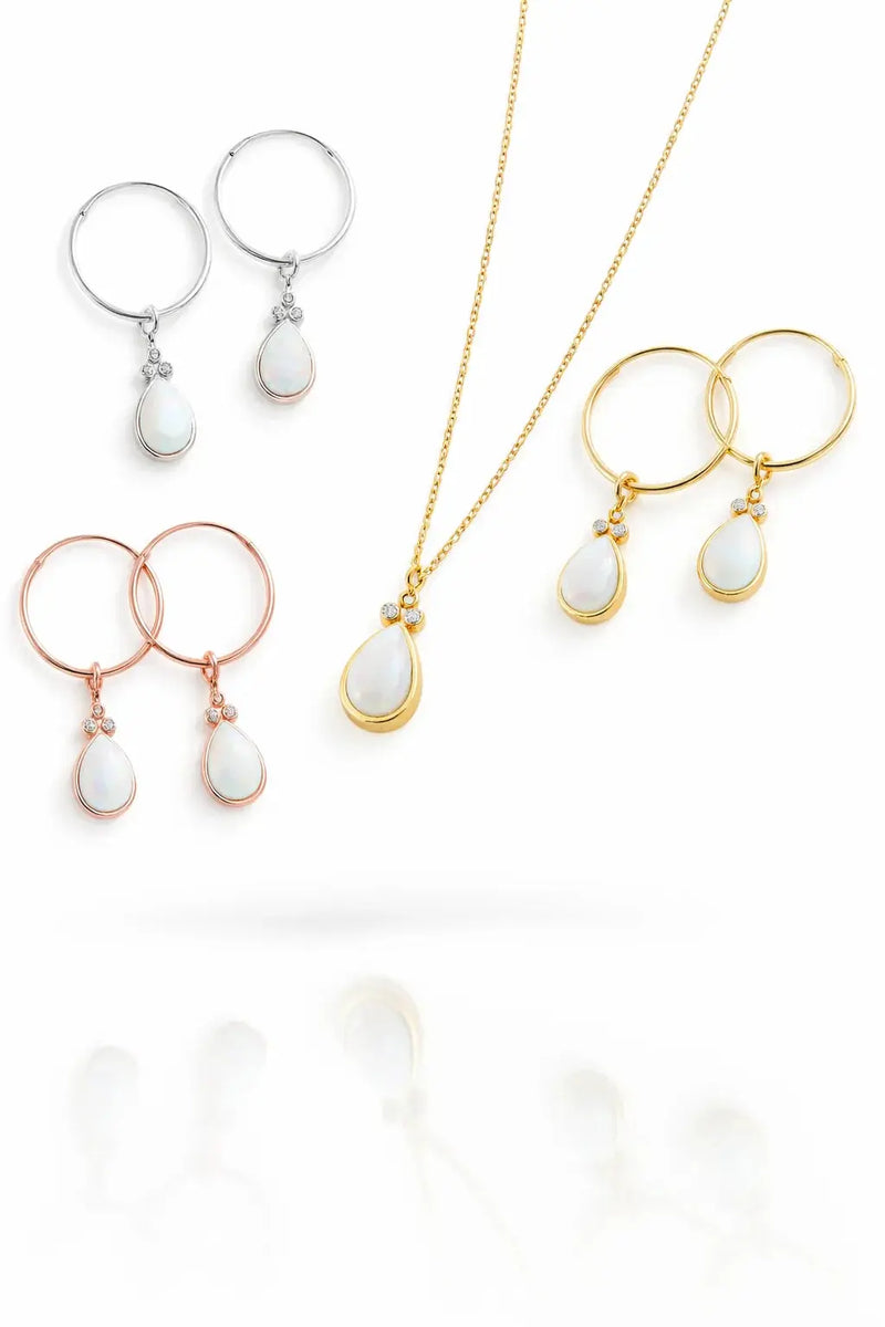 Jewelry collection featuring hoop earrings and pendants in silver, gold, and rose gold with opal accents.