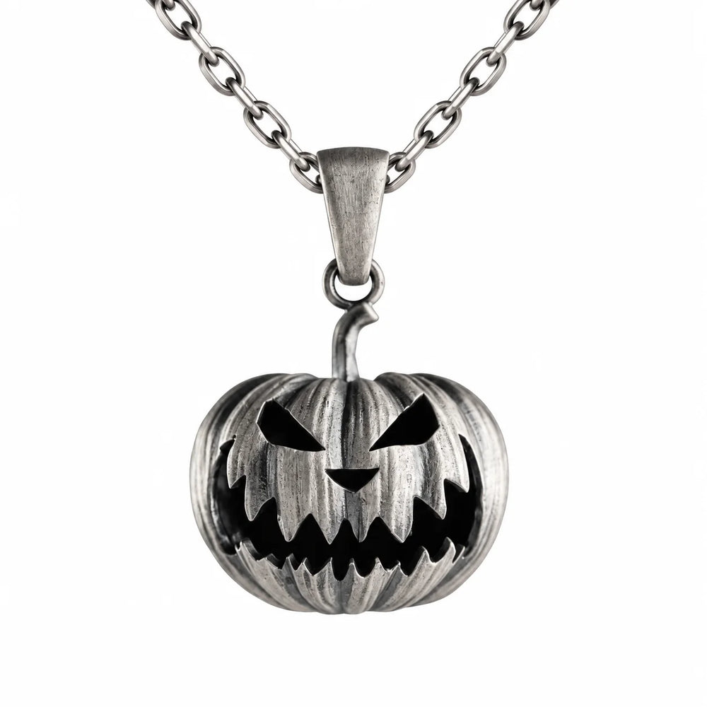 A silver-toned metal pendant necklace featuring a carved jack-o'-lantern pumpkin design with black recessed details, suspended from a matching chain on a plain white background.