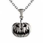A silver-toned metal pendant necklace featuring a carved jack-o'-lantern pumpkin design with black recessed details, suspended from a matching chain on a plain white background.
