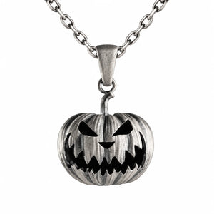 A silver-toned metal pendant necklace featuring a carved jack-o'-lantern pumpkin design with black recessed details, suspended from a matching chain on a plain white background.