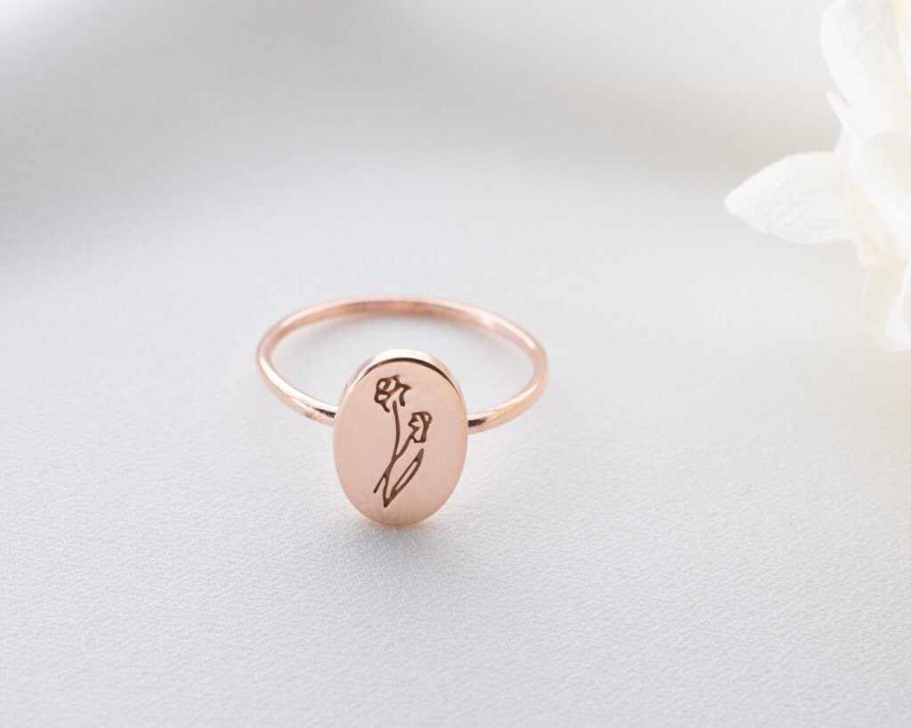 silver floral signet ring on warm textured background