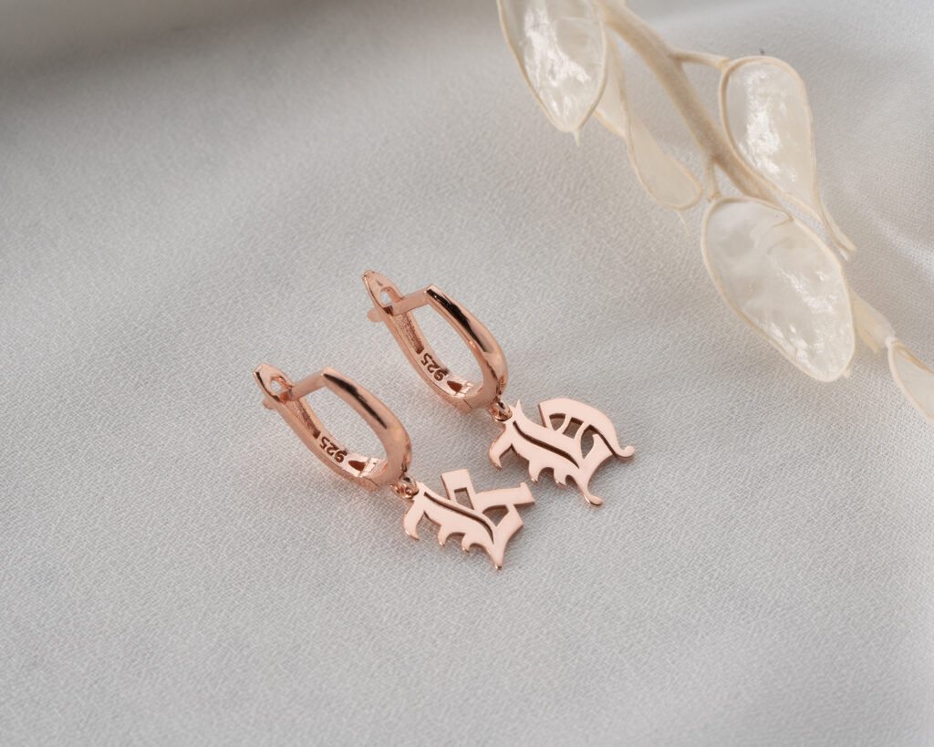 rose gold monogram drop earrings on textured background