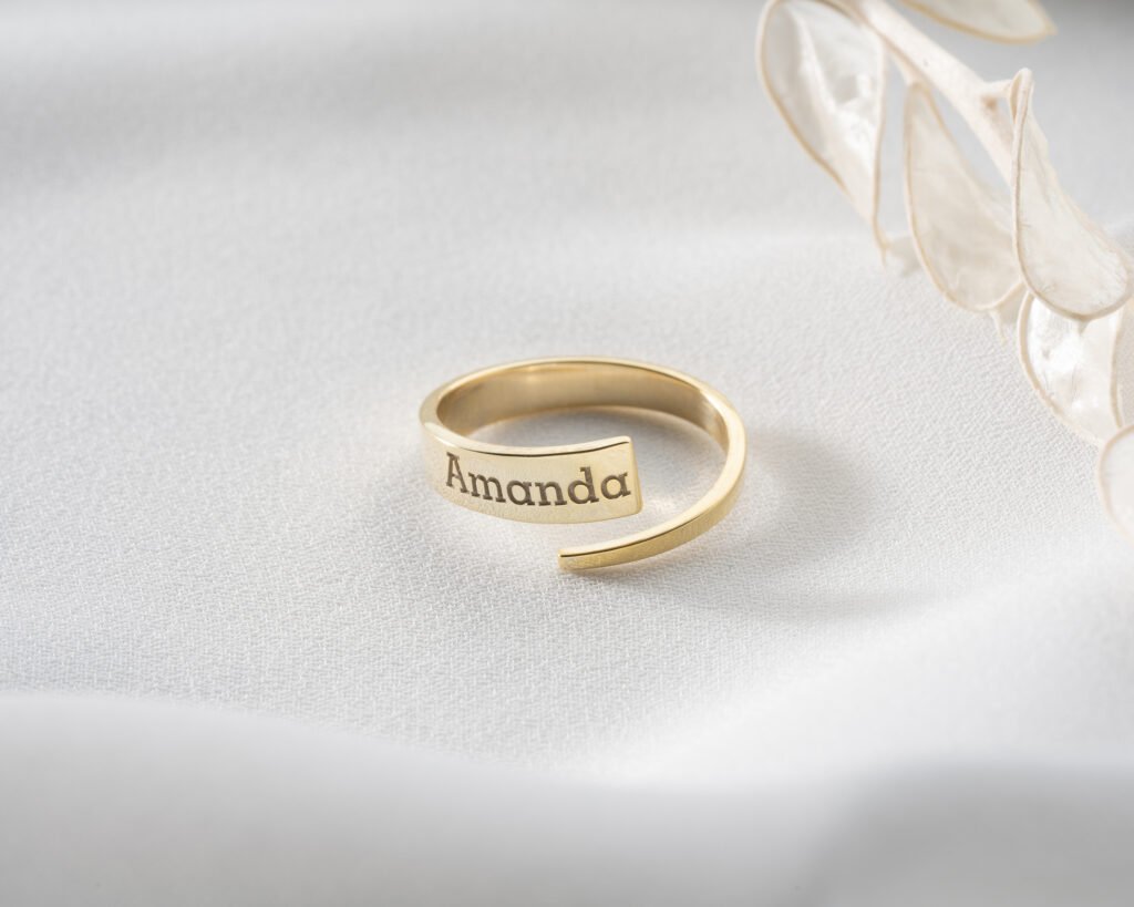 gold spiral name ring “Kelly” on bright background