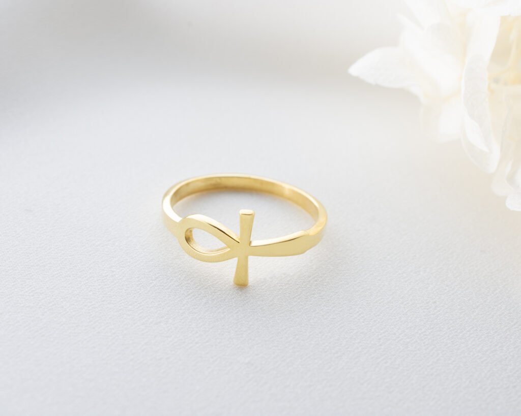 gold-plated cross infinity ring on textured surface