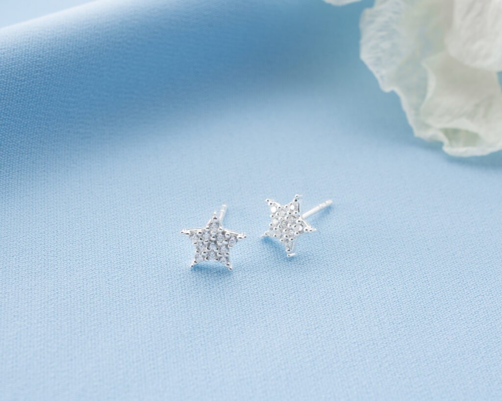 Silver star stud earrings on white background