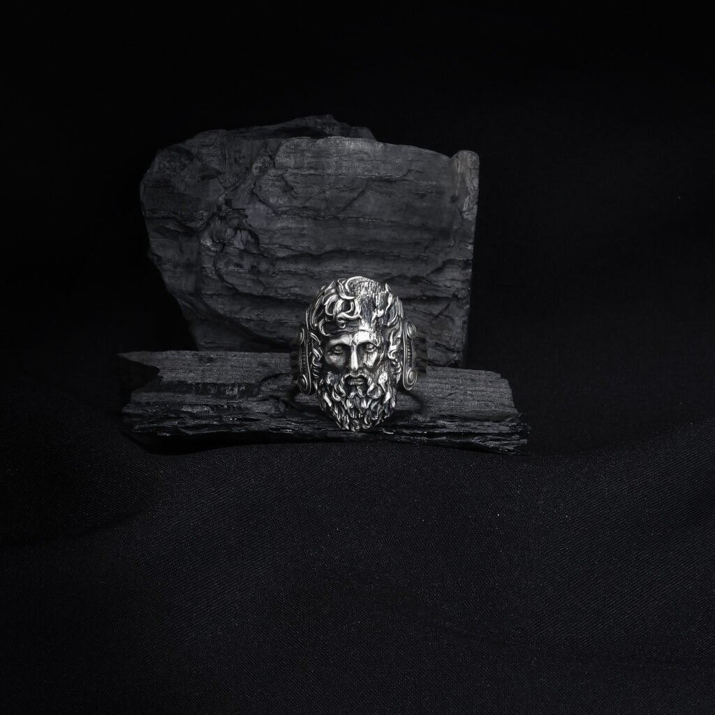 antique silver mythic god ring on dark textured background