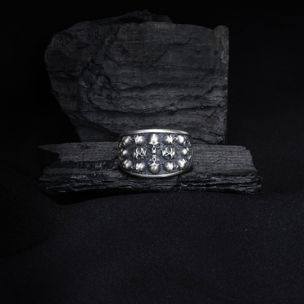antique silver skull cluster ring on dark textured background
