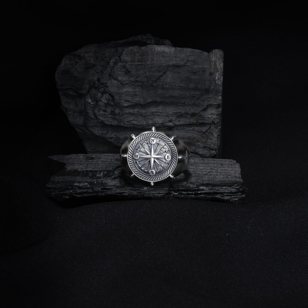 antique silver compass anchor ring on dark textured background